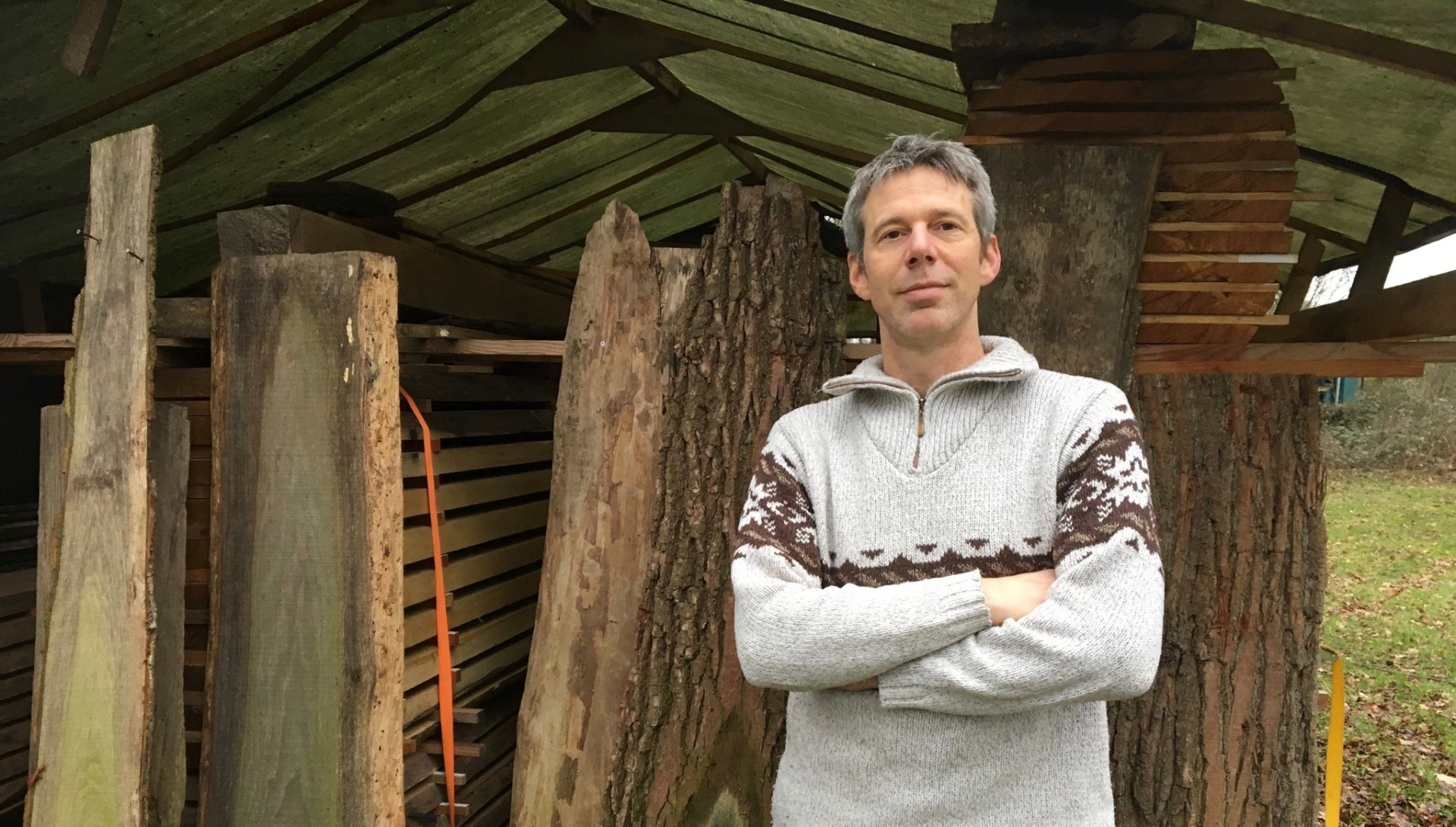 Foto van Meubelmaker Joppe Overberg voor een stapel scharrelhout