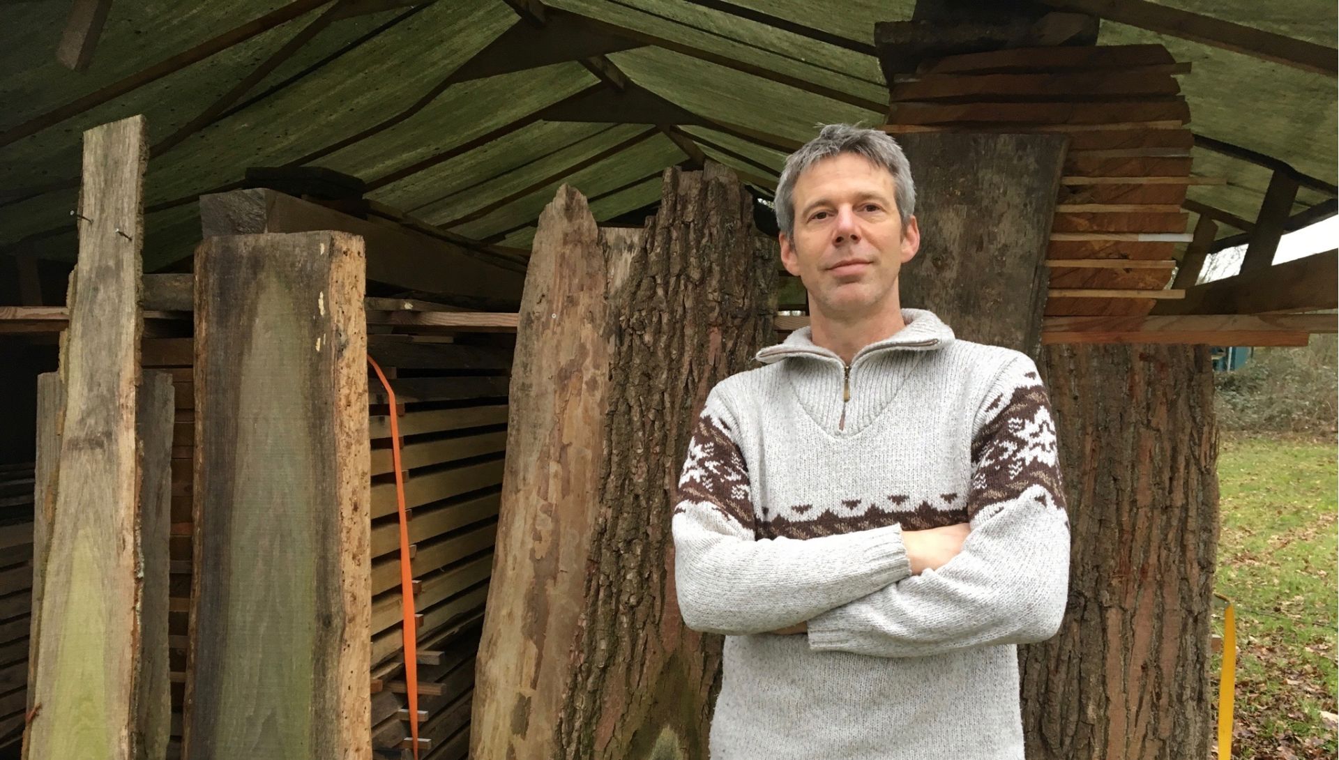 Foto van Meubelmaker Joppe Overberg voor een stapel scharrelhout
